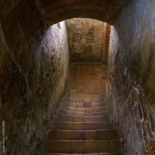 Staircase in an old castle going to the dungeon. Medieval and gothic concept. Background of text.