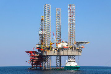 Offshore oil platform and supply ship are in Persian Gulf.