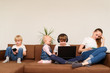 © somemeans - Three kids and mom sitting next to use laptop and phone. Internet addiction.