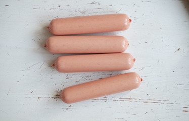 4 sausages on a white table