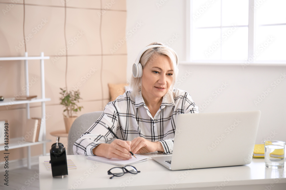 Mature woman using laptop for online learning at home