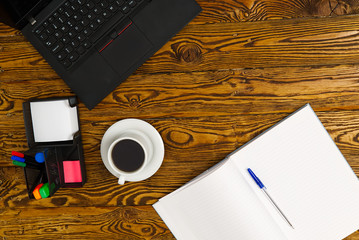 Poster - Laptop with cup of coffee on old brown wooden table. Top view to Notebook with cup of fresh coffee in home office in village.