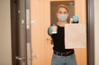 © Parilov - Food and coffee delivery cardboard boxes woman in protective mask. Quarantine coronavirus online shopping