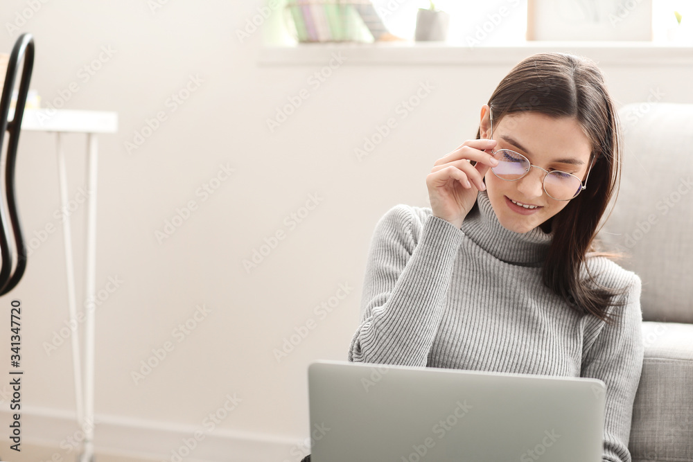 Young woman with laptop working at home