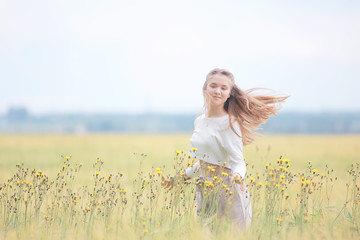 Wall Mural - blonde with long hair in autumn field / concept of happiness health young adult model in summer landscape