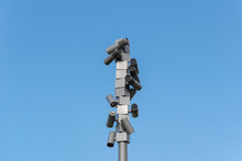 Low Angle View Of Security Cameras Against Clear Blue Sky