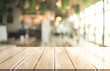 © DEEP PIXEL - Empty wooden table top with lights bokeh on blur restaurant background, 3D Rendering