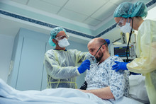 Doctors Giving Artificial Respiration To Patient In Emergency Care Unit Of A Hospital