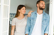 © Westend61 - Attractive young couple standing in the door together at home and looking outside