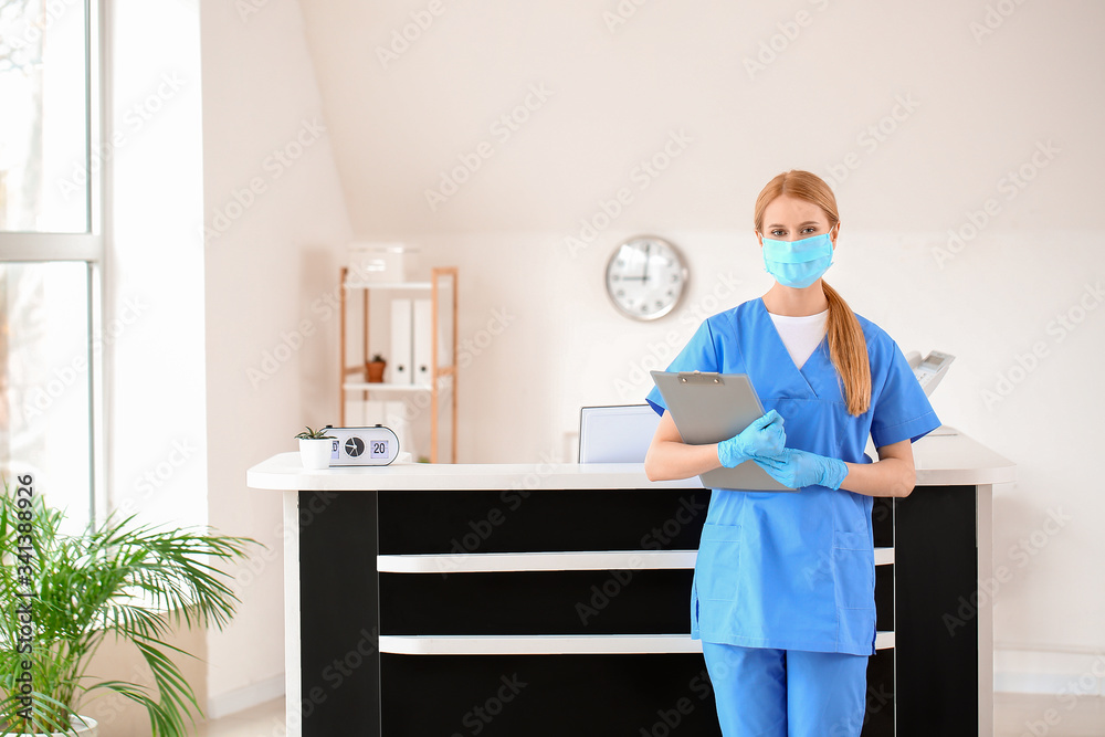 Female receptionist near desk in clinic