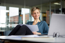 Smiling Businesswoman Working At Desk In Office