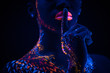 © Roman - young sensual woman keep silence, show silence gesture at camera. cropped female with fluorescent prints on body, cosmic fantastic prints glowing in UV lights. body art concept