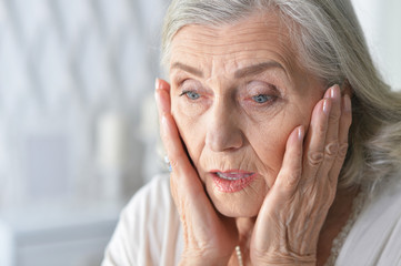 Canvas Print - Close up portrait of sad ill senior woman