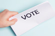 © ivanchik29 - Paper with vote inscription, male hand on a blue background
