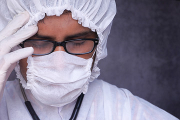 hero doctor with mask and face shield crying tear due to coronavirus.