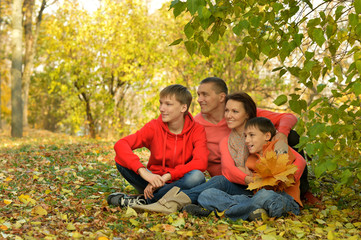 Canvas Print - Family of four relaxing in autumn park