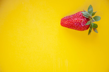 juicy red strawberries lies on a yellow background
