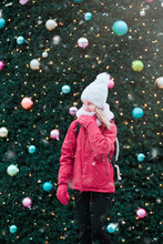 Teenage Girl Looking Away While Standing Against Christmas Tree