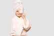 © Svetlana - Smiling beautiful kid girl with towel on head hold cotton pad disk cleansing face skin with cleanser. Happy girl remove makeup enjoy healthy clean skincare beauty treatment concept