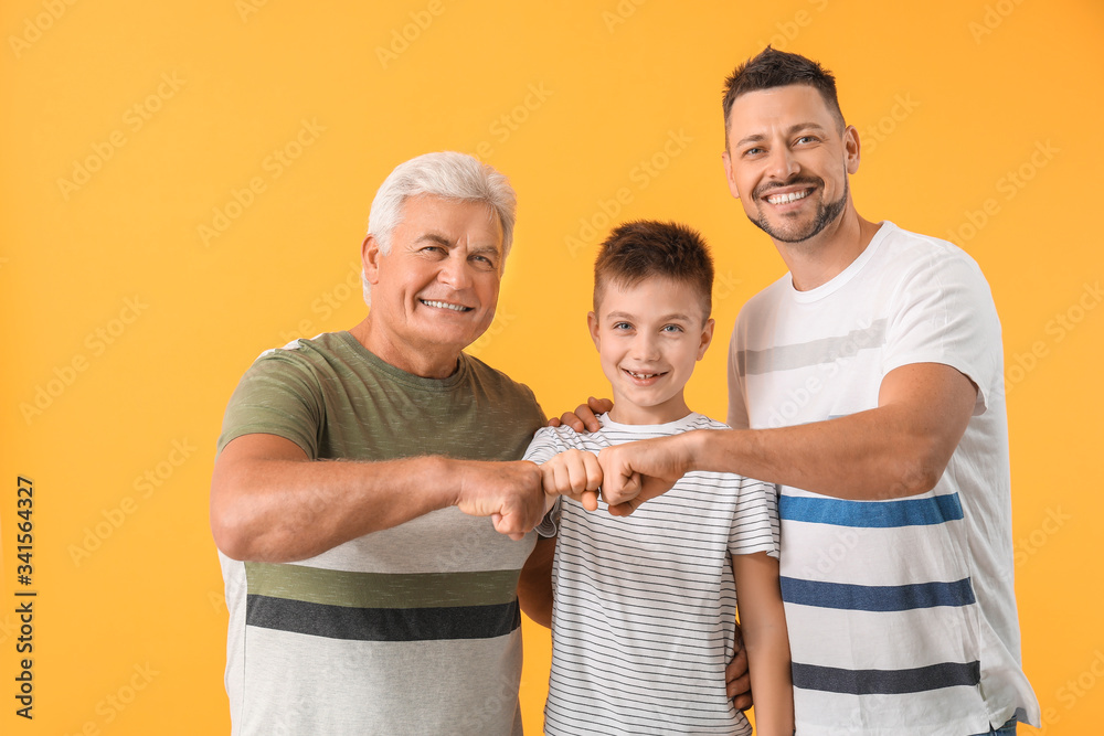 Man with his father and son bumping fists against color background