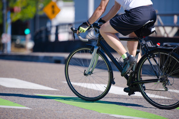 Man rides a bicycle crossing a city street preferring an active lifestyle