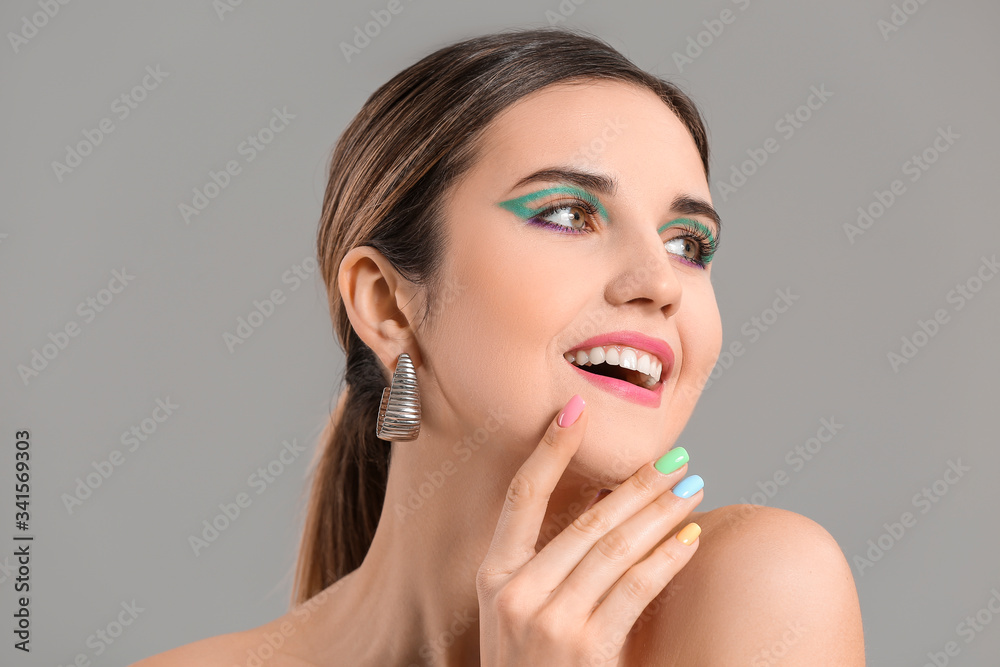 Young woman with beautiful manicure on grey background