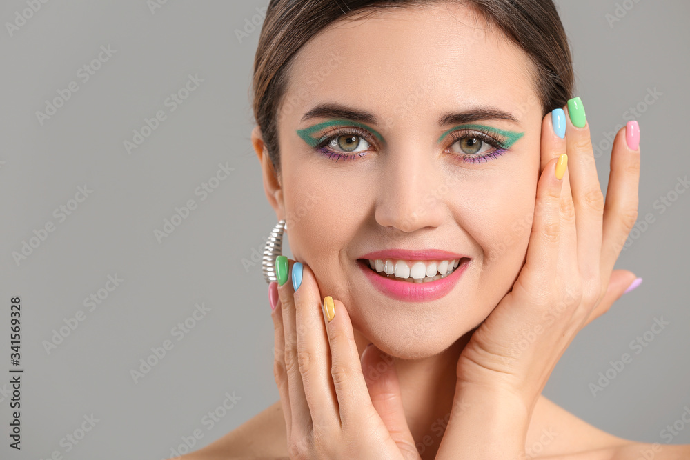 Young woman with beautiful manicure on grey background