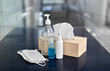 © Syda Productions - hygiene and disinfection concept - close up of different hand sanitizers, liquid soap, face protective medical masks and paper tissues on table