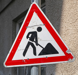 Road works road sign next to a building