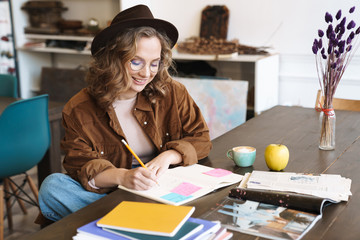 Poster - Image of joyful woman smiling while studying with exercise books