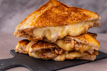 Four stacked servings of chicken and melted cheese sandwich