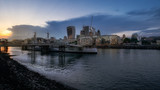 Fototapeta  - HMS Belfast warship and a view across the River Thames to the financial District buildings in London at sunset, England, Great Britain