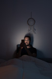 Fototapeta Morze - hombre mirando al movil en la cama men looking at the phone in bed