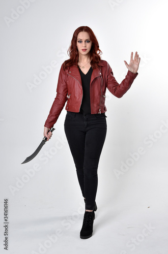Portrait Of A Pretty Girl With Red Hair Wearing Black Jeans And Boots With Leather Jacket Full Length Standing Pose Holding Knife A Studio Background Stock Photo Adobe Stock Knife holding pose by halo91 on deviantart.holding a knife reference by moa #hand #drawing holding knife pose drawing it also will feature a picture of a sort that could be seen in the gallery of. length standing pose holding knife