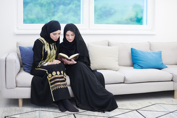 Wall Mural - young muslim women reading Quran at home