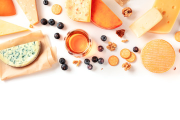 Wall Mural - Cheese and wine tasting and pairing flat lay on a white background with copy space. Many different cheeses, shot from the top