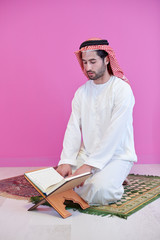 Wall Mural - young arabian muslim man reading Quran at home