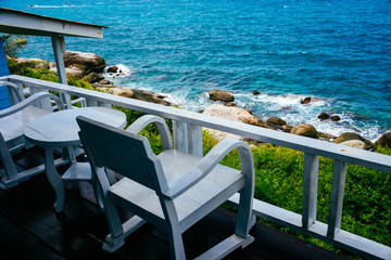 Nice sea view from a balcony of a hotel. Chair with table set on balcony hotel room with ocean view background.