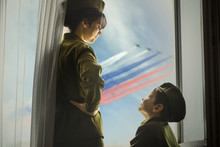 A Girl And A Boy In A Soviet Military Uniform Are Standing At Window. Concept Of Cancelled Parade,  Which Dedicated To The 75th Anniversary Of Victory In The Great Patriotic War In Moscow.