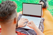 © Алексей Горелов - a man in a red T-shirt lies on an inflatable orange mattress on a summer day in nature and looks at the laptop screen