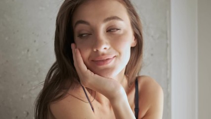 Poster - Close up view of Playful pretty brunette woman in lingerie posing and looking at the camera at home