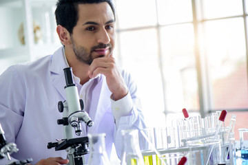 Wall Mural - attractive happiness scientist man lab technician assistant analyzing sample in test tube with micro