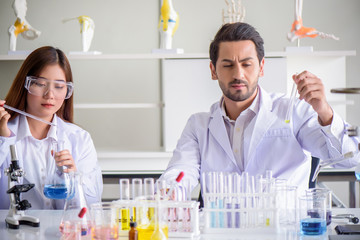 Wall Mural - attractive happiness scientist lab technician assistant analyzing sample in test tube at laboratory.