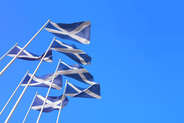 Wall Mural - Scotland flags waving in the wind against a blue sky. 3D Rendering