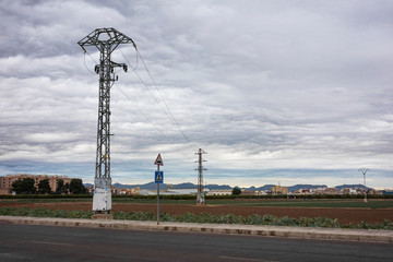 electric tower crossing farm fields