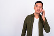 © Ranta Images - Portrait of young Asian man talking on the phone