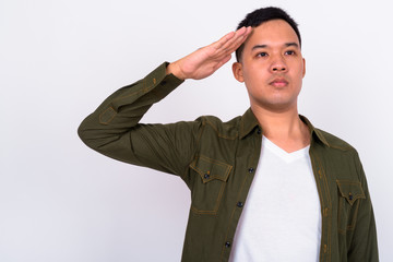 Wall Mural - Portrait of young Asian man saluting while looking away