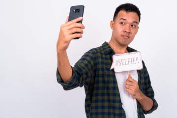 Wall Mural - Portrait of young Asian man taking selfie with paper sign