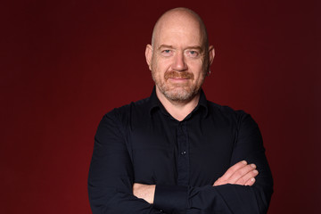 portrait of smiling man arms crossed red background