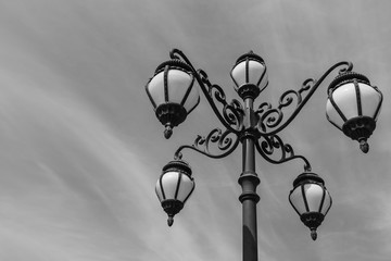 Decorative retro street lamp or lamppost on sky background with black and white